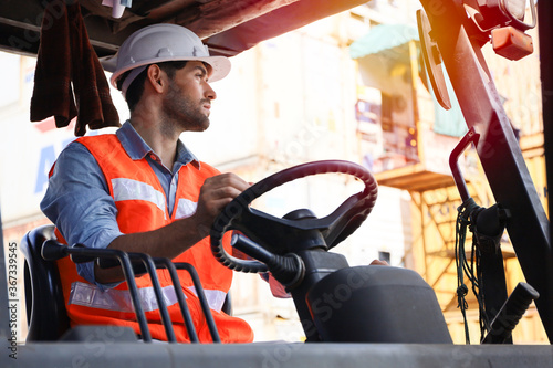A engineering or foreman or driver working at container stock yard with drive a loader forklift steering wheel control for transport handling