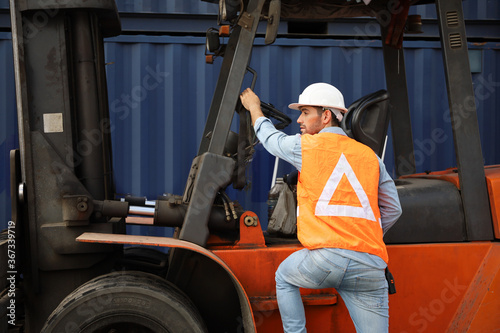 A engineering or technician is working at container stock yard, radio mobile talking communication with loader forklift for transport handling inspection check or maintenance