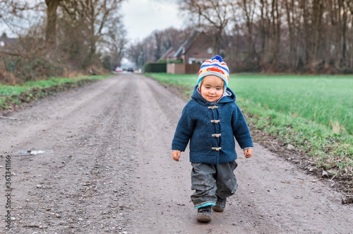 Happy toddler walking on footpath photo