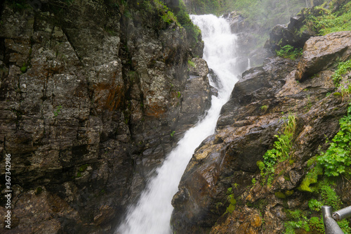 waterfall in the mountains between trees