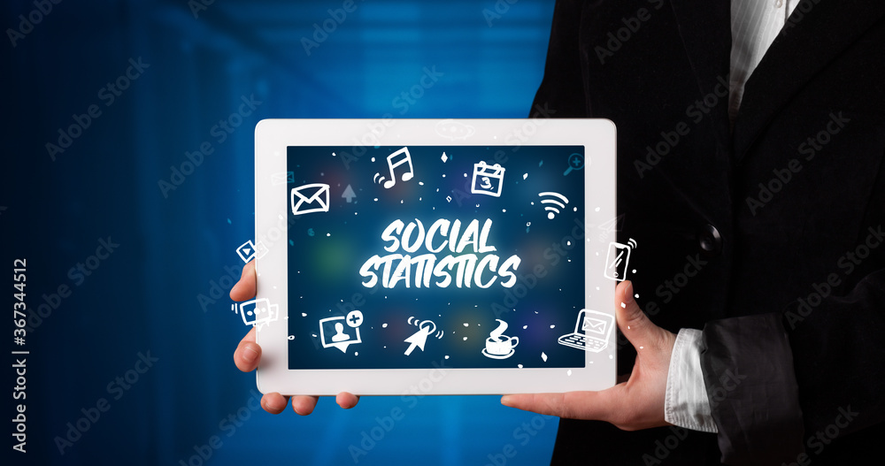 Young business person working on tablet and shows the inscription: SOCIAL STATISTICS Young business person working on tablet and shows the inscription: SOCIAL STATISTICS