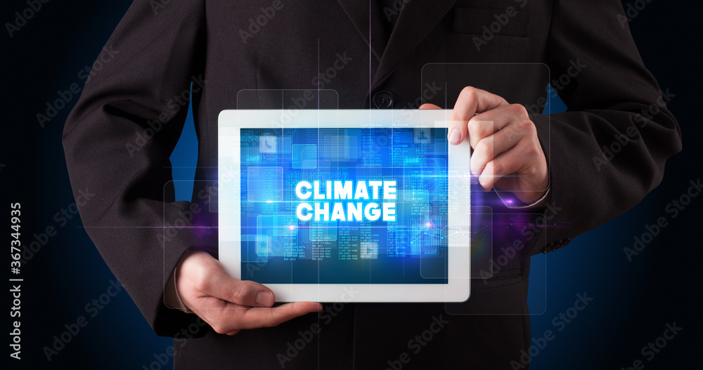 Young business person working on tablet and shows the inscription: CLIMATE CHANGE