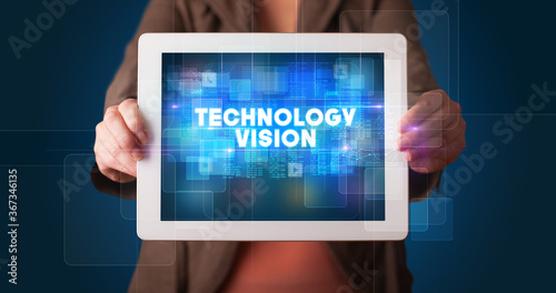 Wallpaper Mural Young business person working on tablet and shows the inscription: TECHNOLOGY VISION Torontodigital.ca