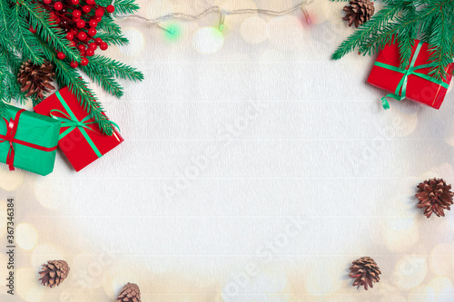 Christmas composition. Christmas gift, pine cones, fir branches, christmas light, garland on white paper background. Top view, copy space