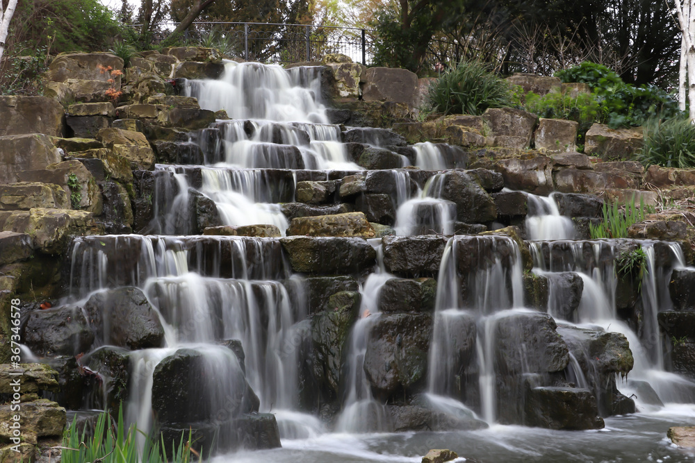 Obraz premium waterfall in the park, long exposure, stones and trees 