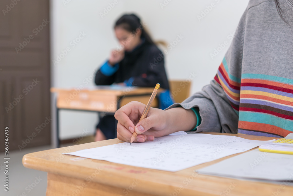 Woman Asian Hands Student testing in exam on exercise taking at high school or university in test room and Writing document exams classroom, back to school and evaluation measurement in education Woman Asian Hands Student testing in exam on exercise taking at high school or university in test room and Writing document exams classroom, back to school and evaluation measurement in education