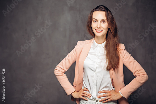 Adult woman with hands on hips on dark background