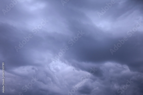 Clouds in blue dark sky. White, fluffy clouds In blue sky. Background nature. Texture cumulus floating on blue sky. Backgrounds concept. Environment, atmosphere. Place for an inscription or logo