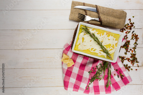 lasagna with rosemary cheese on wooden background