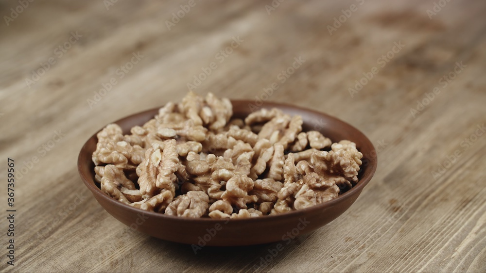 Bowl with walnuts on wooden table Bowl with walnuts on wooden table