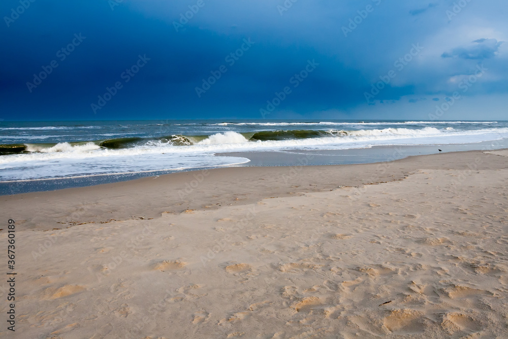 An approaching storm over ocean waves crashing at Assateague Island National Seashore, Maryland