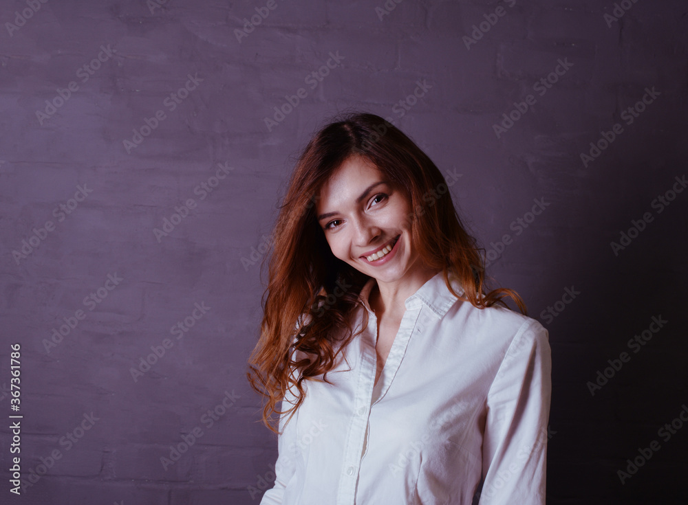 Young woman in white shirt smiling on gray background Young woman in white shirt smiling on gray background