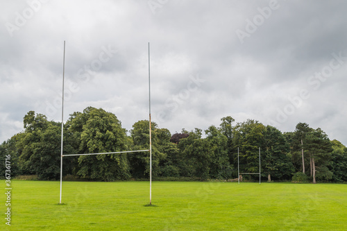 Goal posts on a rugby pitch surrounded by trees