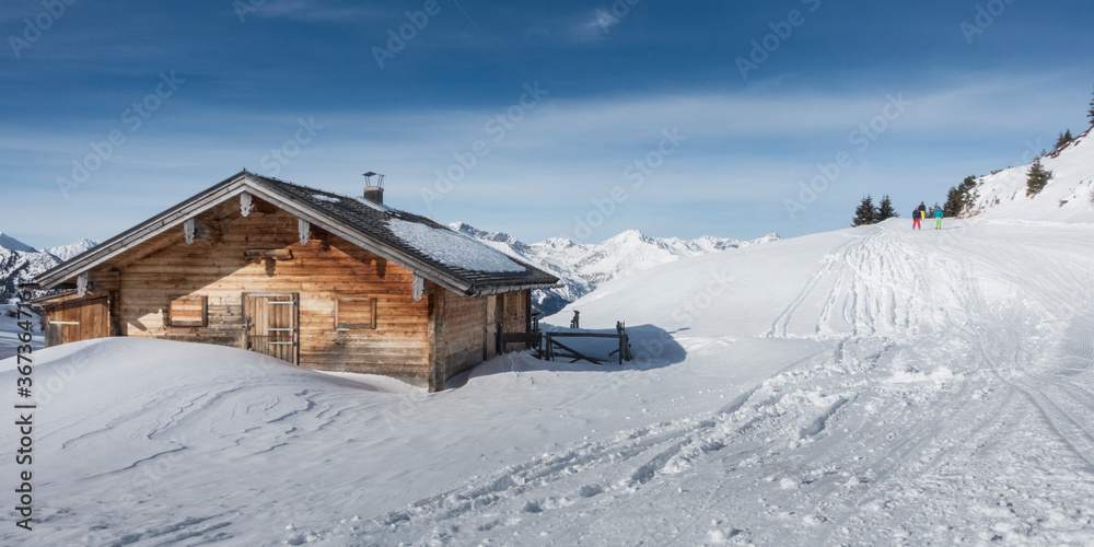 Panoramabild Schigebiet mit Skihütte und Schifahrer in Tirol Österreich
