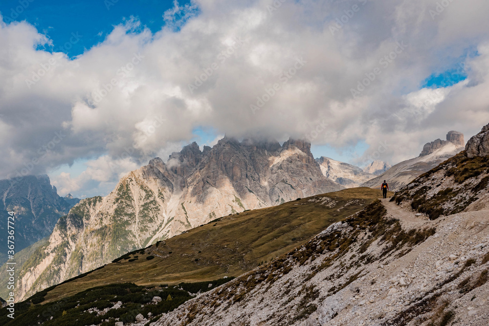 Walker, climber, person on a lonely way through the stony mountains in the italian dolomites, italy