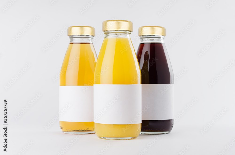 Yellow, red fruit and berries juices collection in glass bottles with cap, white blank labels, group, mock up on white background, template for packaging, advertising, design product, branding. Yellow, red fruit and berries juices collection in glass bottles with cap, white blank labels, group, mock up on white background, template for packaging, advertising, design product, branding.
