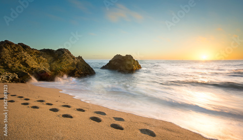 Sunset on the California Coast with Footprints in the Sand