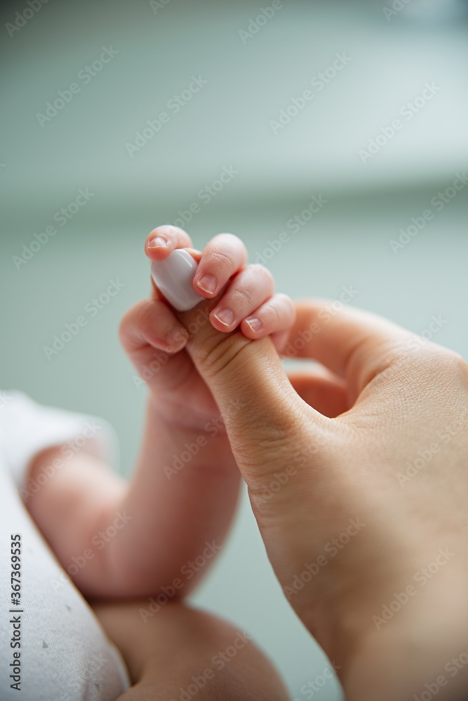 newborn baby holding mom by finger, close-up newborn baby holding mom by finger, close-up