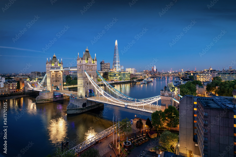Die beleuchtete Skyline von London am Abend mit Tower Bridge und modernen Bürogebäuden entlang der Themse, Großbritannien