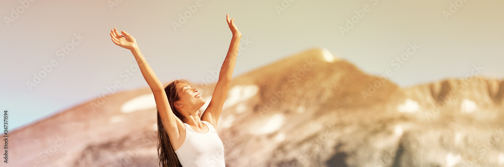 Happy free woman excited with arms up enjoying summer sunshine freedom on nature travel outdoor mountains landscape banner panorama. Smiling Asian girl. - obrazy, fototapety, plakaty 