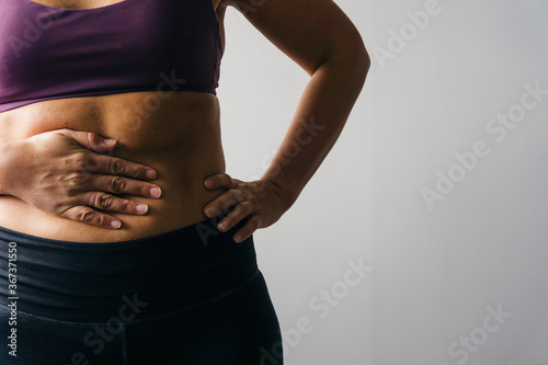 Woman in active wear holding hand on stomach photo