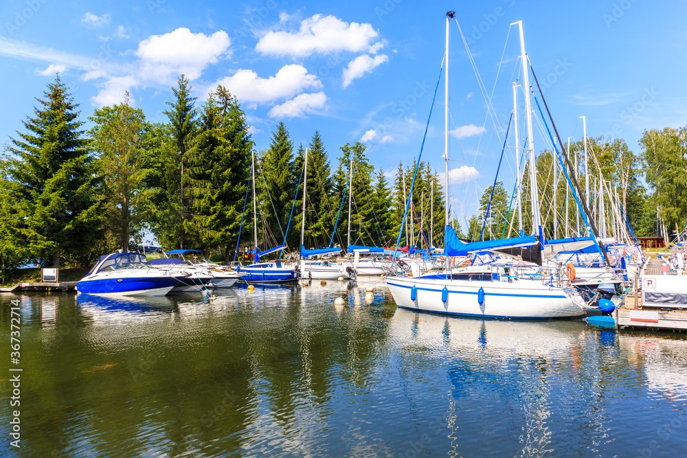 Sailing boats on lake Beldany in Piaski port on summer sunny day, Mazury Lake District, Poland
