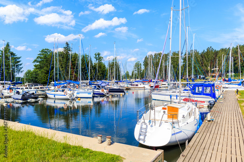 Sailing boats on lake Beldany in Piaski port on summer sunny day, Mazury Lake...