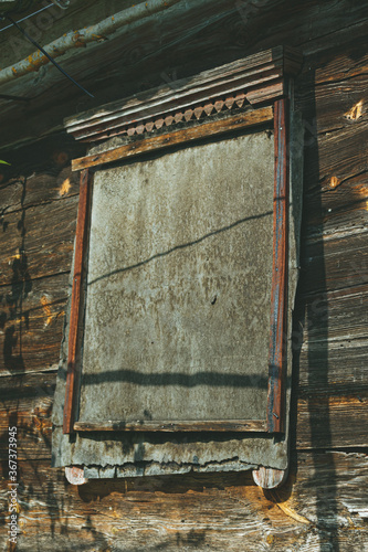 An old abandoned wooden building in a village manor. A structure made of cracked, sun-burned logs. photo