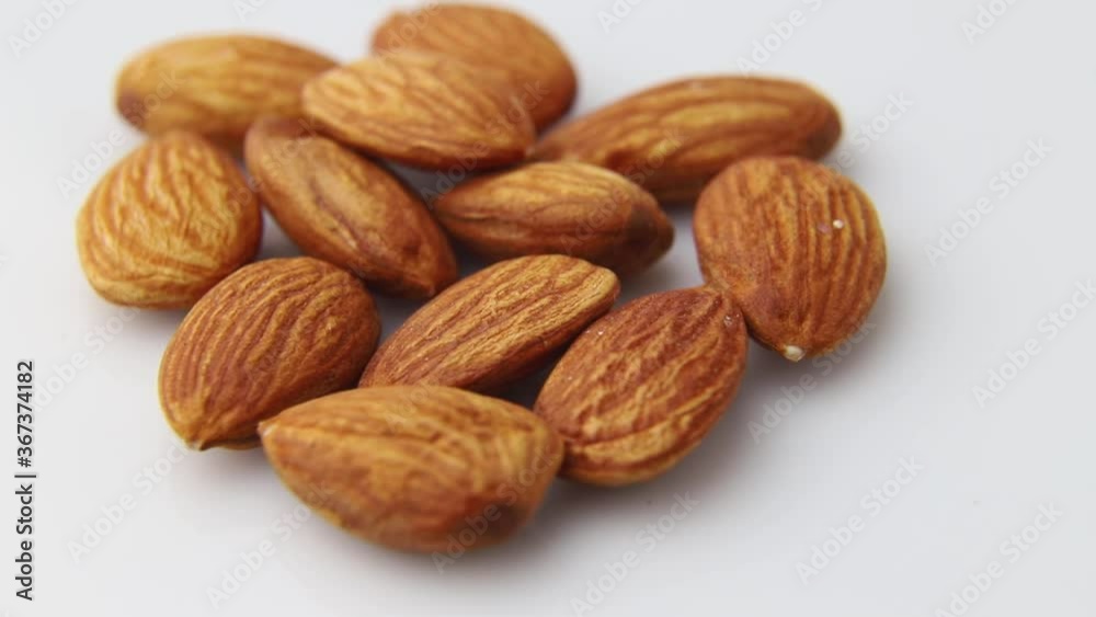 Rotating of almonds on white background. Side view, close up. Rotating of almonds on white background. Side view, close up.