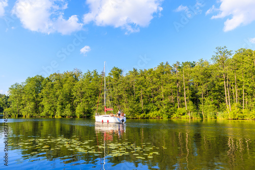 LAKE BELDANY, POLAND - JUN 28, 2020: Sailing boat on Lake Beldany near Ruciane Nida, Masurian Lakes, Poland. This region is popular holiday destination for people of Warsaw city.