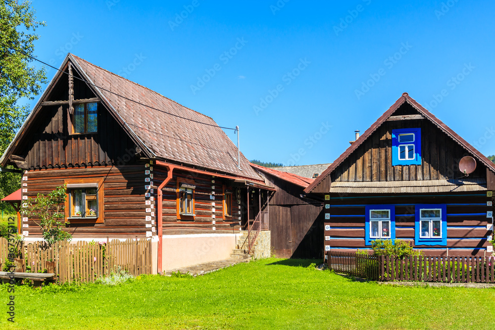 Old traditional rural wooden houses in Osturnia village in Tatra Mountains on beautiful summer sunny day, Slovakia