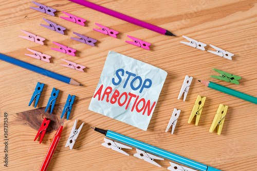 Word writing text Stop Arbotion. Business photo showcasing advocating against the practice of abortion Prolife movement Colored clothespin papers empty reminder wooden floor background office photo