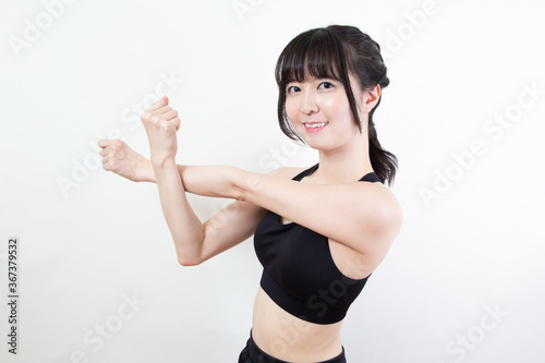 腕と肩を伸ばすストレッチをする女性