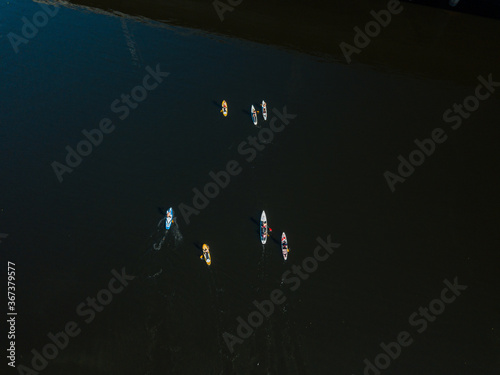 Kayak boats sail along the Dnieper River. Sunny summer day, aerial drone shot