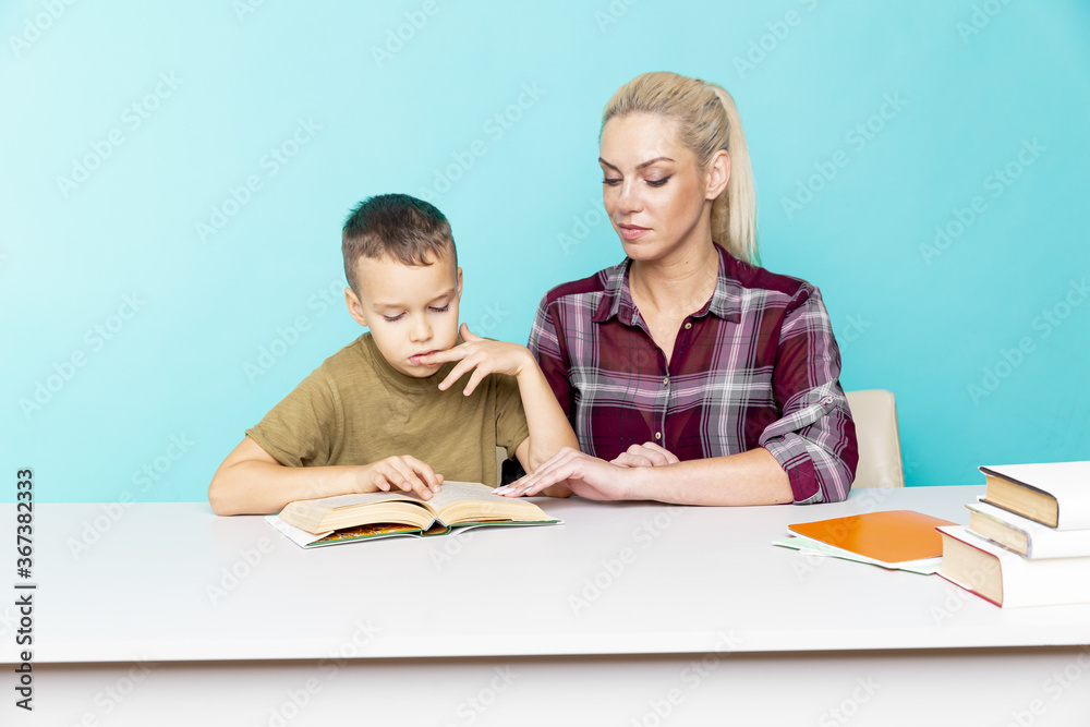 Mother helping her son with homework over isolated pink background. Distant education. Mother helping her son with homework over isolated pink background. Distant education.