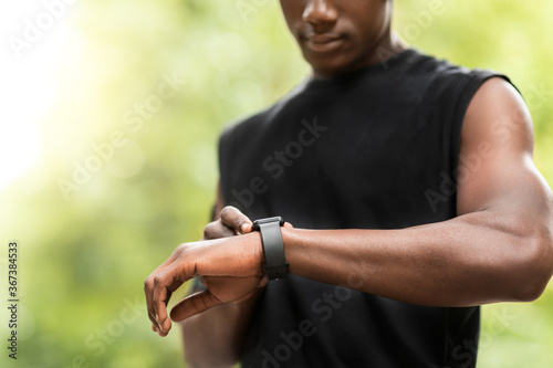 Cropped of black sportsman using his smartwatch