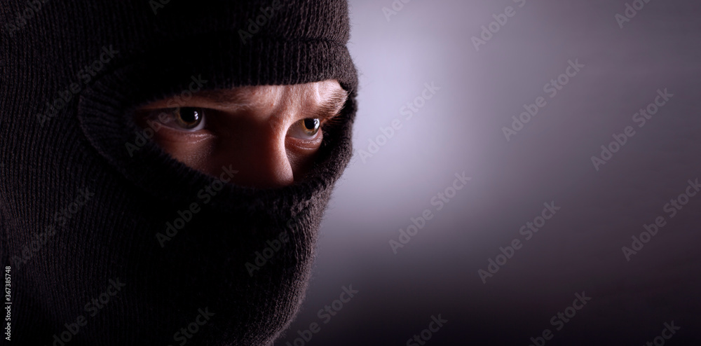angry man in a balaclava on a dark background. Rebellious protester in a mask angry man in a balaclava on a dark background. Rebellious protester in a mask