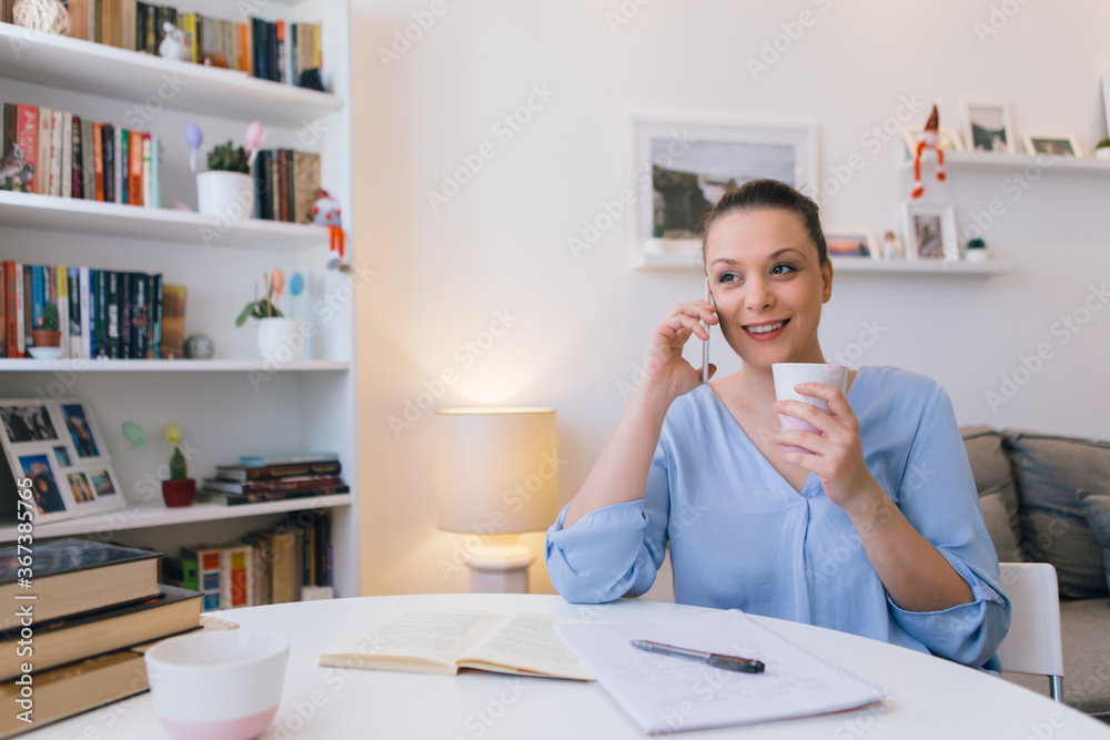 Young woman working at home and using mobile phone Young woman working at home and using mobile phone