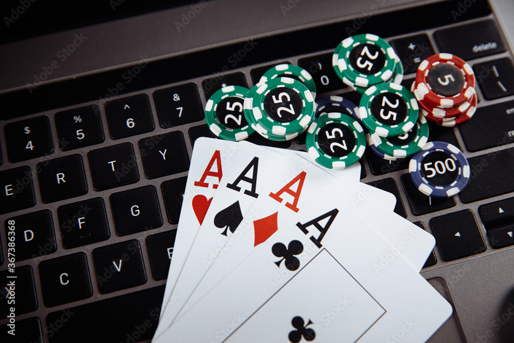 Obraz premium Online casino concept. Gambling chips and playing cards on laptop keyboard.