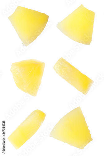 Canned pineapple pieces flying on white background