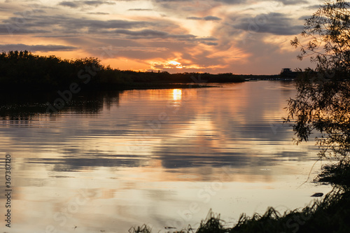 The tranquillity of the sunset, the river or the lake and the silhouettes of the trees