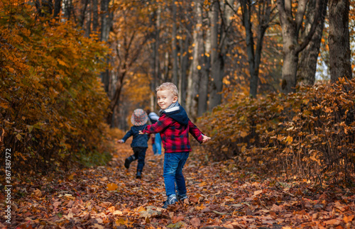 group of Caucasian preschoolers children in stylish clothes run in the autumn park. For various design purposes. Go ahead for the autumn discounts on the children's collection © Natal.is
