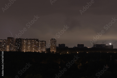 Silhouette of the night city. Lightning over the city. Storm over a residential area. lightning flashes on the horizon.