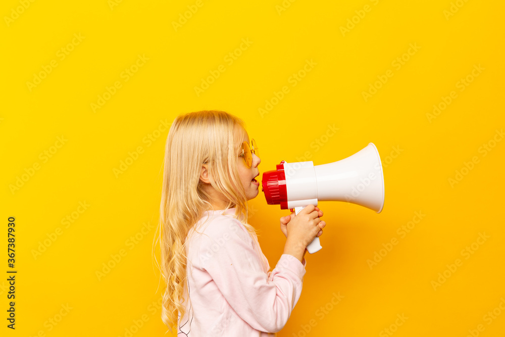 Kid shouting through megaphone. Communication concept. yellow background as copy space for your text. Kid shouting through megaphone. Communication concept. yellow background as copy space for your text.