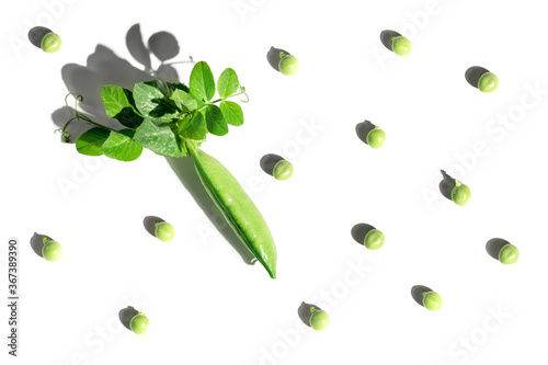 Pattern from pods of green peas and individual peas with shadow on white isolated background. Fresh vegetables, vitamins. Flat lay. Healthy food concept.