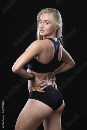 Charming young blonde in a sports top on a dark background. Black and white portrait of a white caucasian girl. © pridneprovskiy