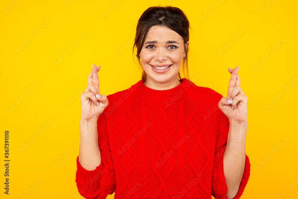 Woman in sweater wish something standing in the yellow studio isolated Woman in sweater wish something standing in the yellow studio isolated