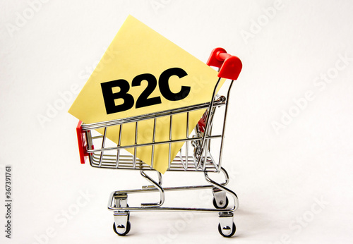 Shopping cart and text B2C on white paper note list. Shopping list, business concept on white background.