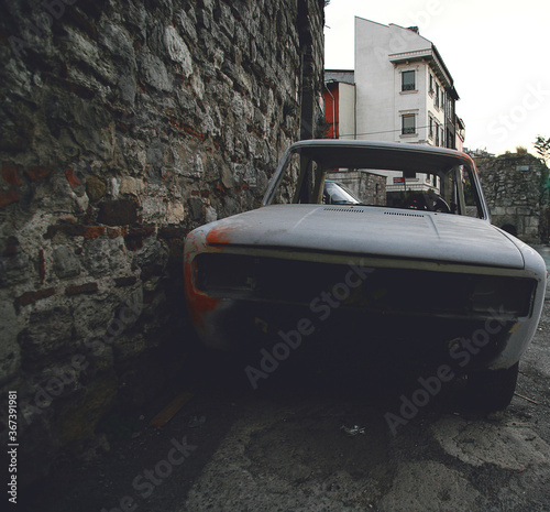 Doorless old white car. In front of the historic walls. photo