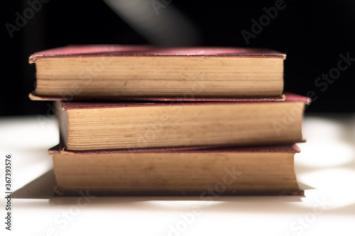 Detailed view of stack of three old books with crimson covers